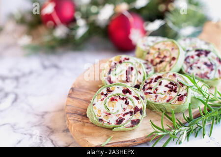 Freschi Fatti in casa a base di mirtillo palustre pinwheels fatta con crema di formaggio, di mirtilli rossi secchi, noci, formaggio di capra e rosmarino pronto per le vacanze. Foto Stock