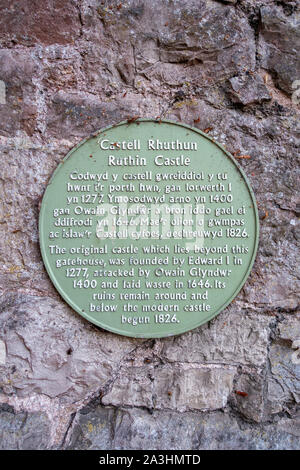 La placca per spiegare la storia di Ruthin Castle, Galles del Nord, su una parete di mattoni al di fuori del castello. Ruthin Castle è ora un hotel. Foto Stock