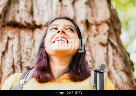 Giovane donna di fronte a un albero Foto Stock