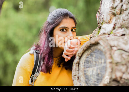 Giovane donna tra gli alberi Foto Stock