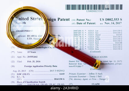 Il close up foto di Huawei brevetto US e lente di ingrandimento. Tecnologie cinesi sono sotto inchiesta. Foto Stock