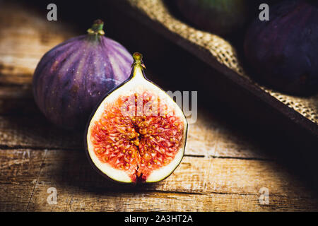 Fichi freschi fette su di un tavolo di legno Foto Stock