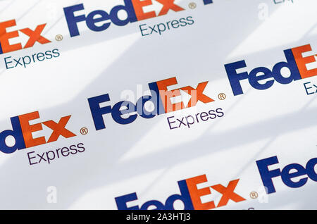 Più FedEX logo su una grande tela con la luce naturale del sole che cade su di esso. La profondità di campo è utilizzato. Foto Stock
