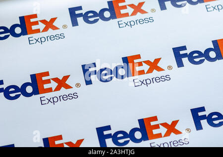 Più FedEX logo su una grande tela con la luce naturale del sole che cade su di esso. La profondità di campo è utilizzato. Foto Stock