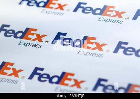 Più FedEX logo su una grande tela con la luce naturale del sole che cade su di esso. La profondità di campo è utilizzato. Foto Stock