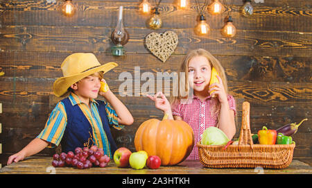 Bambini presentando farm raccolto lo sfondo di legno. Motivi per cui ogni bambino dovrebbe sperimentare l'agricoltura. Responsabile per il daily farm faccende. Gli agricoltori per bambini ragazza ragazzo verdure raccolto. Azienda agricola a conduzione familiare. Foto Stock