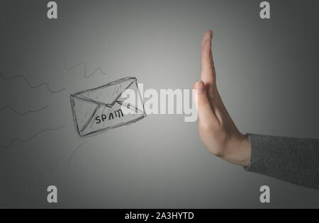 Stop Spam concetto. Il gesto di arresto dalla mano femminile e spam lettera su sfondo grigio. Foto Stock