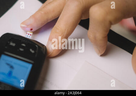 Una persona che controlla il suo diabete valori Foto Stock