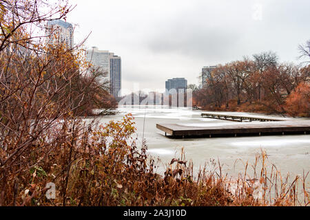Laghetto del nord in Lincoln Park Chicago ed è circondata da piante e alberi nel tardo autunno con neve e ghiaccio Foto Stock
