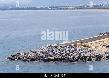 Blocchi in calcestruzzo di un frangiflutti sulla riva del mare. Il mare Mediterraneo al largo delle coste della Turchia Foto Stock