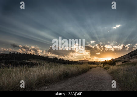 Colorado tramonto sul sentiero escursionistico come flussi di sole attraverso le nuvole Foto Stock