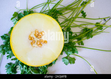 Aprire halff di Melone Galia più fresco e verde sullo sfondo di prezzemolo. Scatto dall'alto Foto Stock