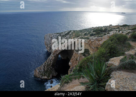 Vista sul mare con grotte e scogliere al tramonto Foto Stock