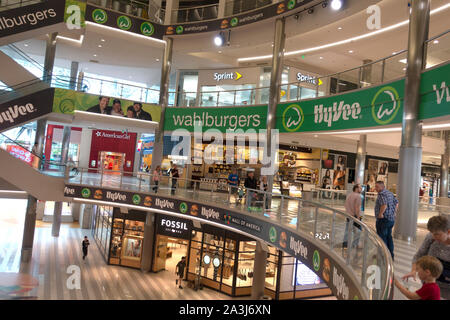 Gli amanti dello shopping presso il centro commerciale Mall of America sotto i banner pubblicitari per Wahlburgers gestito da HyVee insieme con altri negozi. Bloomington MN Minnesota USA Foto Stock