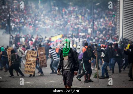 Quito, Ecuador. 08 ott 2019. Un dimostrante è in possesso di una pietra in mano ad una massiccia protesta contro il Presidente Moreno in materia di politica economica. La confederazione dei popoli indigeni (CONAIE) ha chiamato per un importante marzo contro il prezzo del carburante aumenta. In vista dei disordini, il governo ha dichiarato lo stato di emergenza e spostato dalla capitale di Guayaquil. Credito: Juan Diego Montenegro/dpa/Alamy Live News Foto Stock