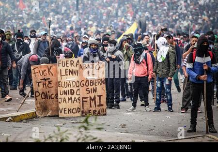 Quito, Ecuador. 08 ott 2019. "Lenin out', 'governo senza FMI', sorge sulla precaria scudi di manifestanti mascherato in una massiccia protesta contro il Presidente Moreno's politiche economiche. La confederazione dei popoli indigeni (CONAIE) ha chiamato per un importante marzo contro il prezzo del carburante aumenta. In vista dei disordini, il governo ha dichiarato lo stato di emergenza e spostato dalla capitale di Guayaquil. Credito: Juan Diego Montenegro/dpa/Alamy Live News Foto Stock