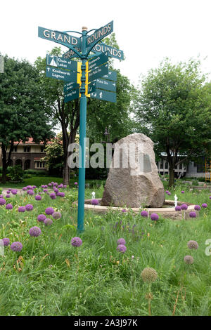 Grand Rounds segno a lago dell'isola Parkway per andare in bicicletta è circondato da un giardino fiorito di tall fiori viola. Minneapolis Minnesota MN USA Foto Stock