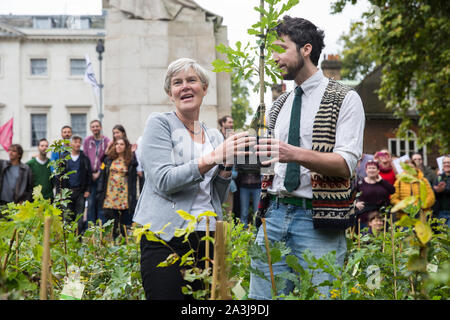 Londra, Regno Unito. 8 Ottobre, 2019. Kate Green, manodopera MP per Stretford e Urmston, riceve un albero dalla ribellione di estinzione attivisti del clima in Palazzo Vecchio Cantiere sulla seconda giornata internazionale di proteste di ribellione. Gli attivisti ha creato una neonata foresta di vasi di alberi nativi al di fuori del Parlamento come parte di un'iniziativa denominata rimboschire Massa e poi sono stati presentati ai parlamentari per chiedere al governo di impianto di miliardi di alberi in tutto il Regno Unito e il supporto la piantagione di trilioni di più in tutto il mondo. Credito: Mark Kerrison/Alamy Live News Foto Stock