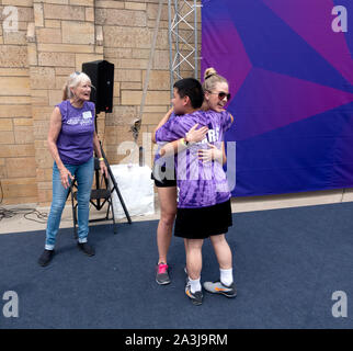 Teenage ragazzo asiatico ottenendo un abbraccio dal membro del personale in Special Olympics cerimonia di premiazione sulla St Thomas University campus. St Paul Minnesota MN USA Foto Stock