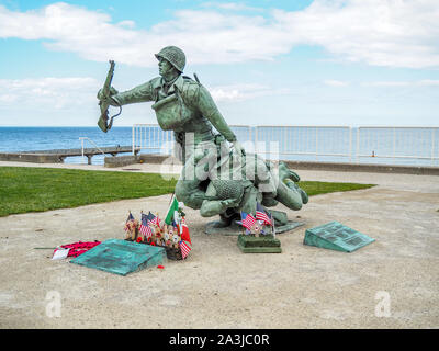 Memorial raffigurante soldato ferito che porta il compagno alla spiaggia di Omaha, in Normandia, Francia, il settantacinquesimo anniversario dell'invasione. Foto Stock