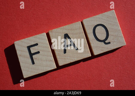 FAQ acronimo di frequently asked questions in 3d alfabeto di legno lettere isolate su uno sfondo rosso Foto Stock