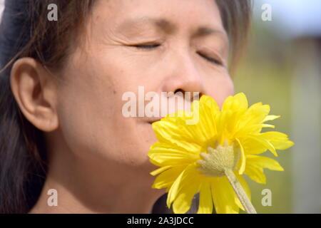 Ritratto di una donna Senior fiori profumati Foto Stock