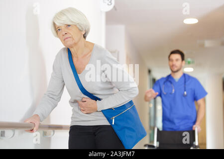 Uomo che cerca di aiutare senior femmina Foto Stock