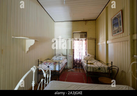 Camera con letto in ferro battuto di antiquariato letti singoli al vecchio e storico Hotel Imperial Hotel nel piccolo borgo rurale di Ravenswood, Queensland, QLD, Australia Foto Stock