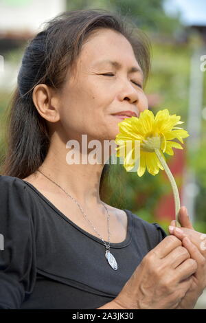 Ritratto di una persona asiatica profumati fiori Foto Stock