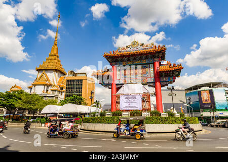 Bangkok, Tailandia - 19 Ottobre 2017: Locale tuk tuk trasporto passa per il punto di riferimento principale porta orientale in area di Chinatown. Foto Stock