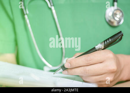 Medico,studenti medici prendere note i risultati di trattamento del paziente nella parte anteriore della sala operatoria. Foto Stock
