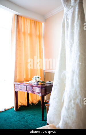 Un matrimonio bouquet di peonie e rose giacente su un tavolo vintage in appartamento per preparare la sposa per la celebrazione del matrimonio e in attesa di t Foto Stock