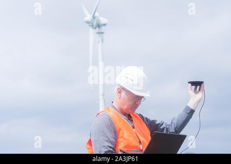 I vecchi ingegnere energetico nella parte anteriore di un mulino a vento Foto Stock