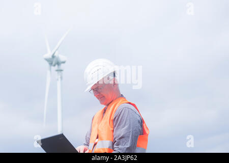 I vecchi ingegnere energetico nella parte anteriore di un mulino a vento Foto Stock