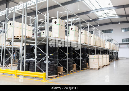 Grande hangar magazzino di aziende industriali e logistiche. Lunghi scaffali con una varietà di scatole. L'industria spaziale e casella di hardware per la consegna Foto Stock