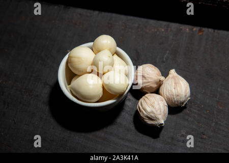 Elephant aglio lampadina singola forma sana aroma di erbe ingrediente alimentare nero su uno sfondo di legno Foto Stock