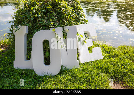 Schiuma di grandi lettere amore in riva al lago Foto Stock