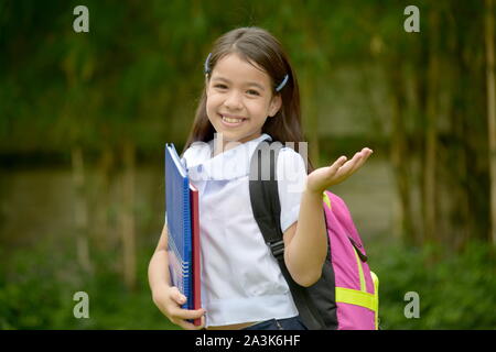 Indeciso Filipina giovane persona che indossa uniformi scolastiche con libri Foto Stock