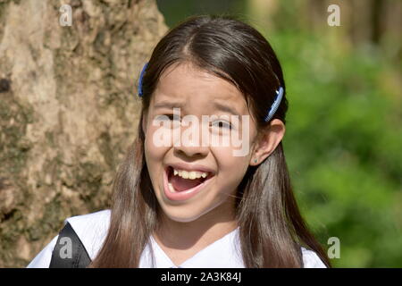 Giovane ragazza diversificata studente facendo facce buffe con i notebook Foto Stock