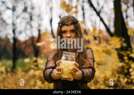 Bella ragazza bionda in Giallo autunno autunno park. Creative giorno di Halloween Foto Stock