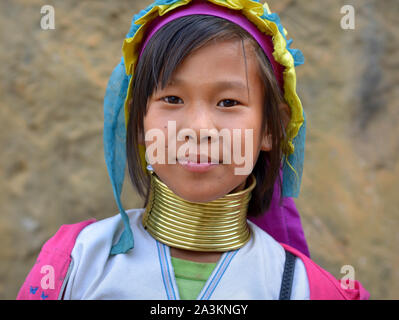 Piuttosto Myanmarese Kayan Lahwi pre-teen ragazza con ottone tribale collo anelli/bobine pone per la fotocamera. Foto Stock