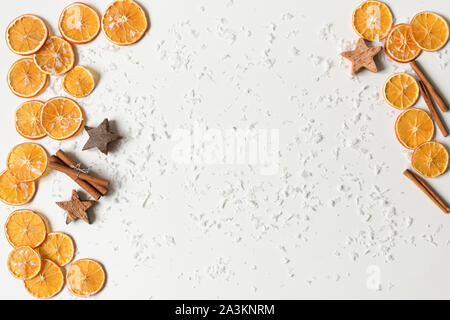 Composizione di cannella ed essiccata arance su sfondo bianco. Appartamento laico, vista dall'alto. Copia dello spazio per il vostro design. Natale o Capodanno concept Foto Stock