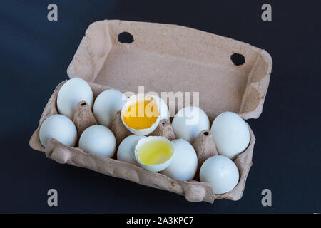 Le uova bianche e un uovo rotto in scatola di cartone con mockup al testo. La proteina naturale. Mangiare sano. Foto Stock