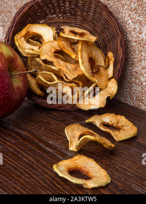 In casa sun-organico essiccato di fette di mela croccante chip Apple, su sfondo di legno e fresh apple. Spazio di copia, close up Foto Stock