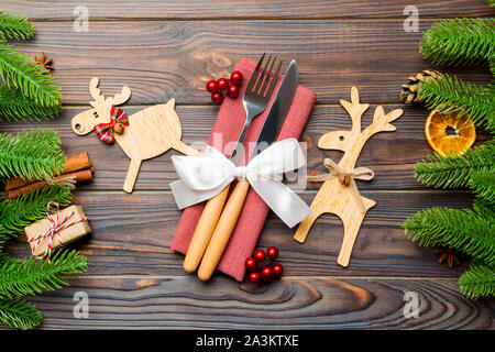 Vista superiore di utensili sul tovagliolo di festa su sfondo di legno. Le decorazioni di Natale con la frutta secca e cannella. Close up di anno Nuovo concetto di cena Foto Stock