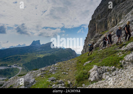 Un gruppo di alpinisti escursionismo su un lato della montagna per un disco arrampicata nelle Dolomiti in Italia Foto Stock