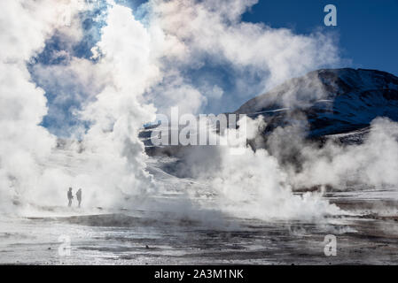 El Tatio geyser in Cile, sagome di turisti tra i vapori e fumarole di sunrise Foto Stock