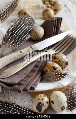 Pasqua messa in tavola con uova di quaglia e piume Foto Stock