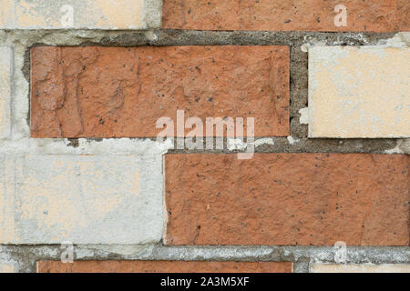 Il bianco e il rosso un muro di mattoni con calcestruzzo negli spazi vuoti Foto Stock