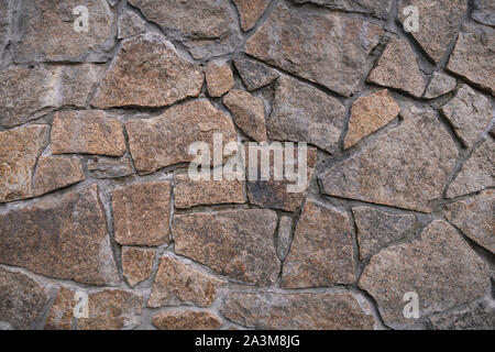 Texture di sfondo del muro di pietra. Frammento di parete da una pietra scheggiata Foto Stock